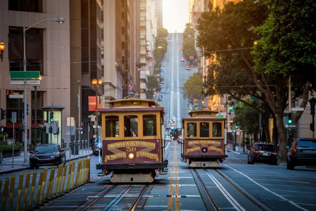 A classic view of historic cable cars on California Street during sunrise in San Francisco, CA.