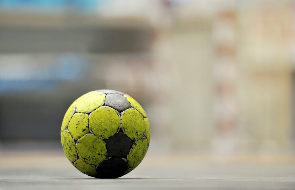 A close-up shot of a handball left out in the sun on hot pavement.